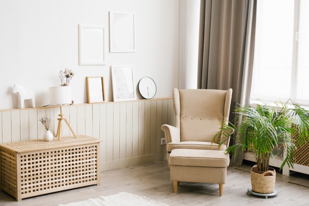 Modern Scandinavian living room interior in beige colors. Armchair, palm tree in a pot